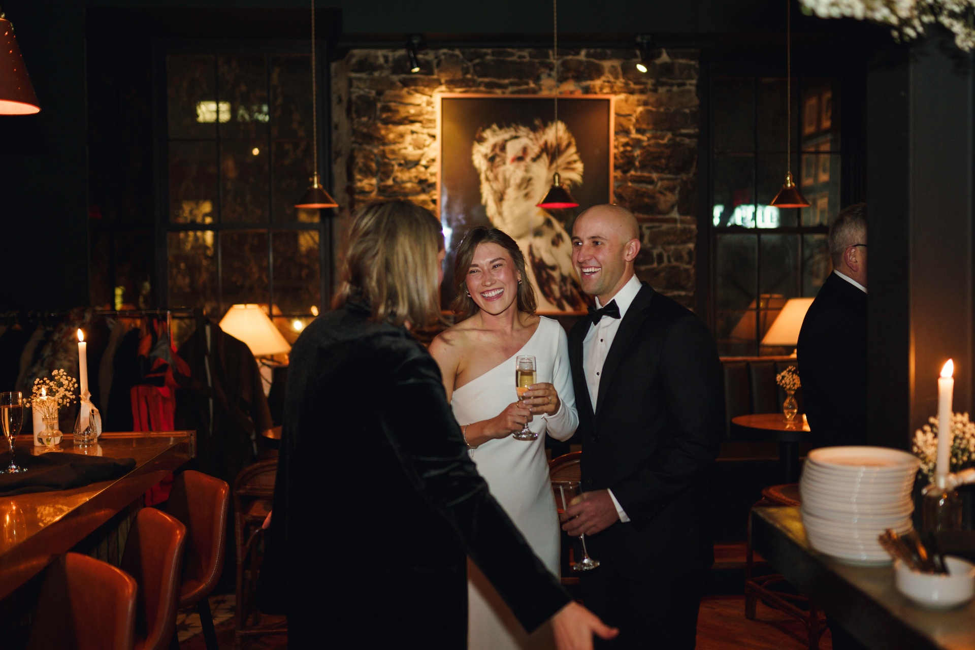 Bride and groom laughing with a guest
