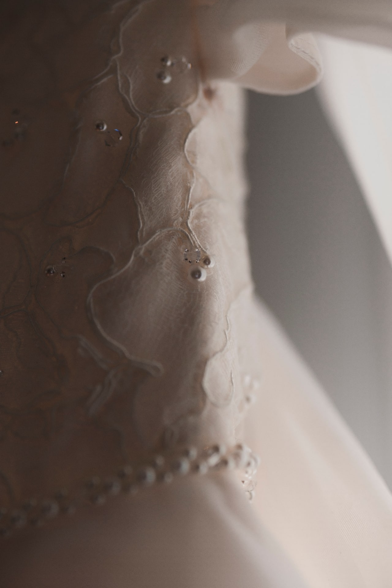 Gros plan sur la dentelle perlée de la robe de mariée